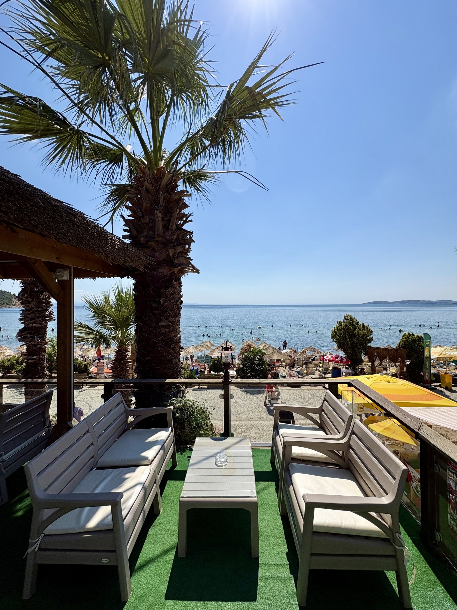 Parıl Hotel plaj alanı, palmiye ağaçları ve deniz manzarası